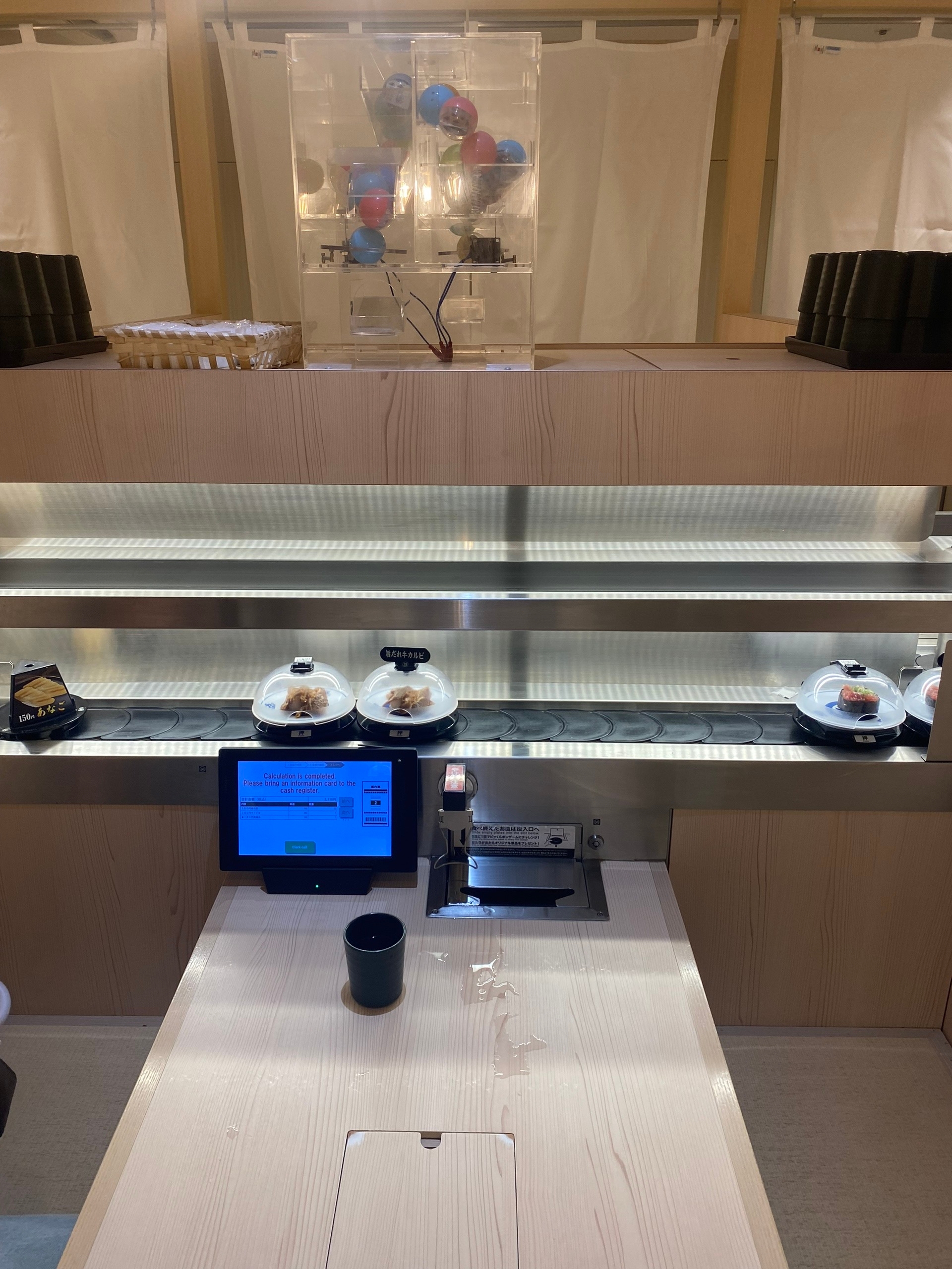 Это conveyer belt sushi. Только конвейер не только для тарелочек с едой (сверху) но ещё и снизу, куда грязную тарелку можно положить. Тарелки сами считаются